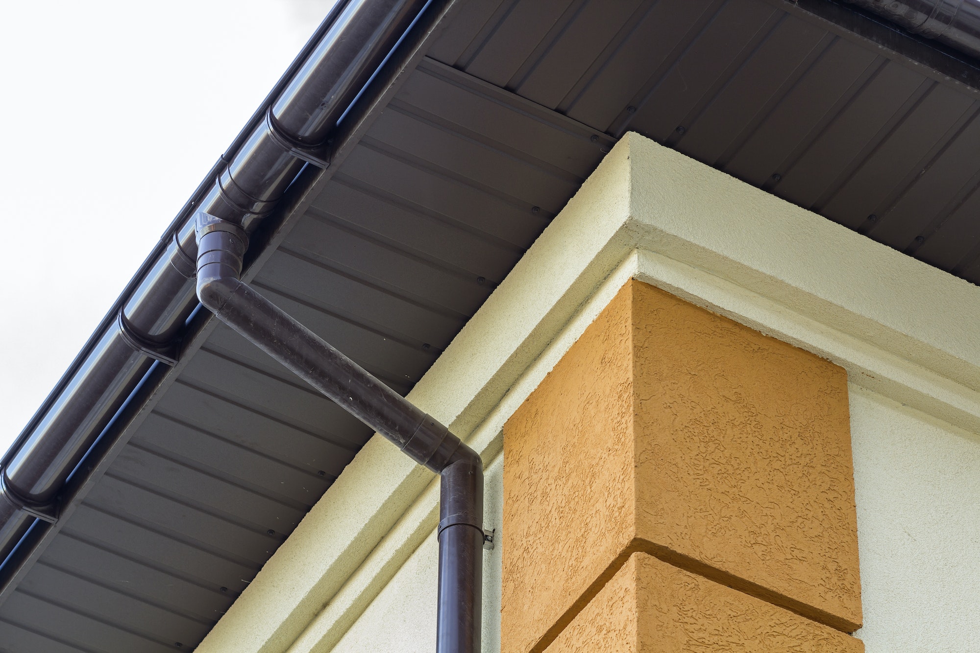 Close-up detail of cottage house corner with brown metal planks siding